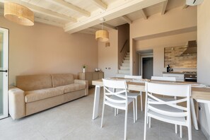 Ein modernes Interieur mit einer Couch, einem Esstisch, Stühlen und einer Treppe.