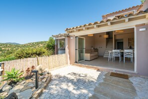 A modern house with a patio, a dining area, and a view of the hills. - Casa Adele Porto Luna (Simius)