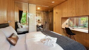 A modern bedroom with a large bed, a desk, and a view of the outdoors. - Theodosius Glamping Mobile Home (Vipava)