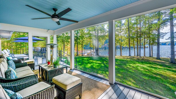 A covered outdoor area with wicker furniture, a ceiling fan, and a view of a lake. - Lakefront Home with Private Dock, Hot Tub, Fireplace, & Central A/C - Free WiFi (Bumpass)