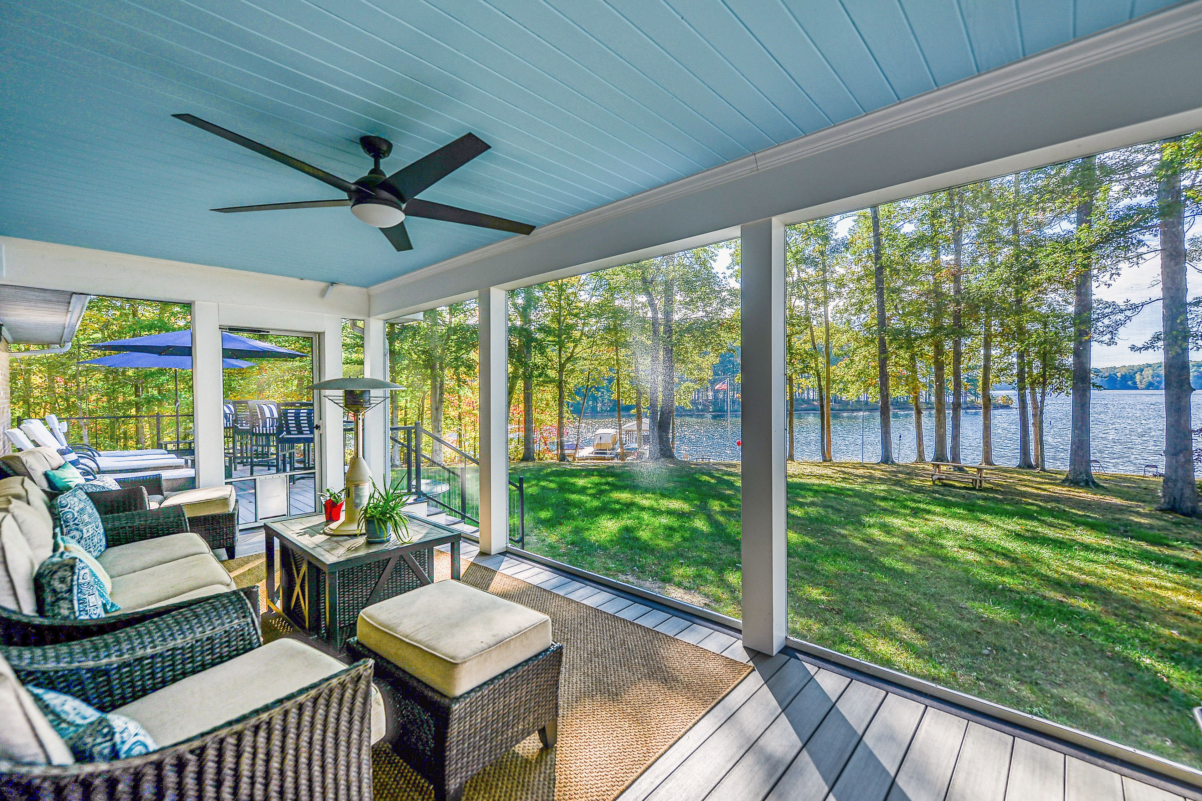 Start the morning on the screened porch, with cushioned seating and a Lake Anna view through the trees.
