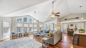 A spacious living room with a large sofa, two armchairs, a coffee table, and a dining area with a table and chairs. - 5BR and 5.5 BA Lakefront Home w/private hot tub and dogs ok! (Bumpass)