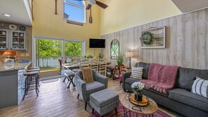 A spacious living area with a high ceiling, a dining area, and a kitchen with a large window. - Beautiful waterfront townhouse w/ perfect location, fireplace & WiFi (Mineral)