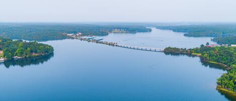 An aerial view of a lake with a bridge connecting two landmasses.