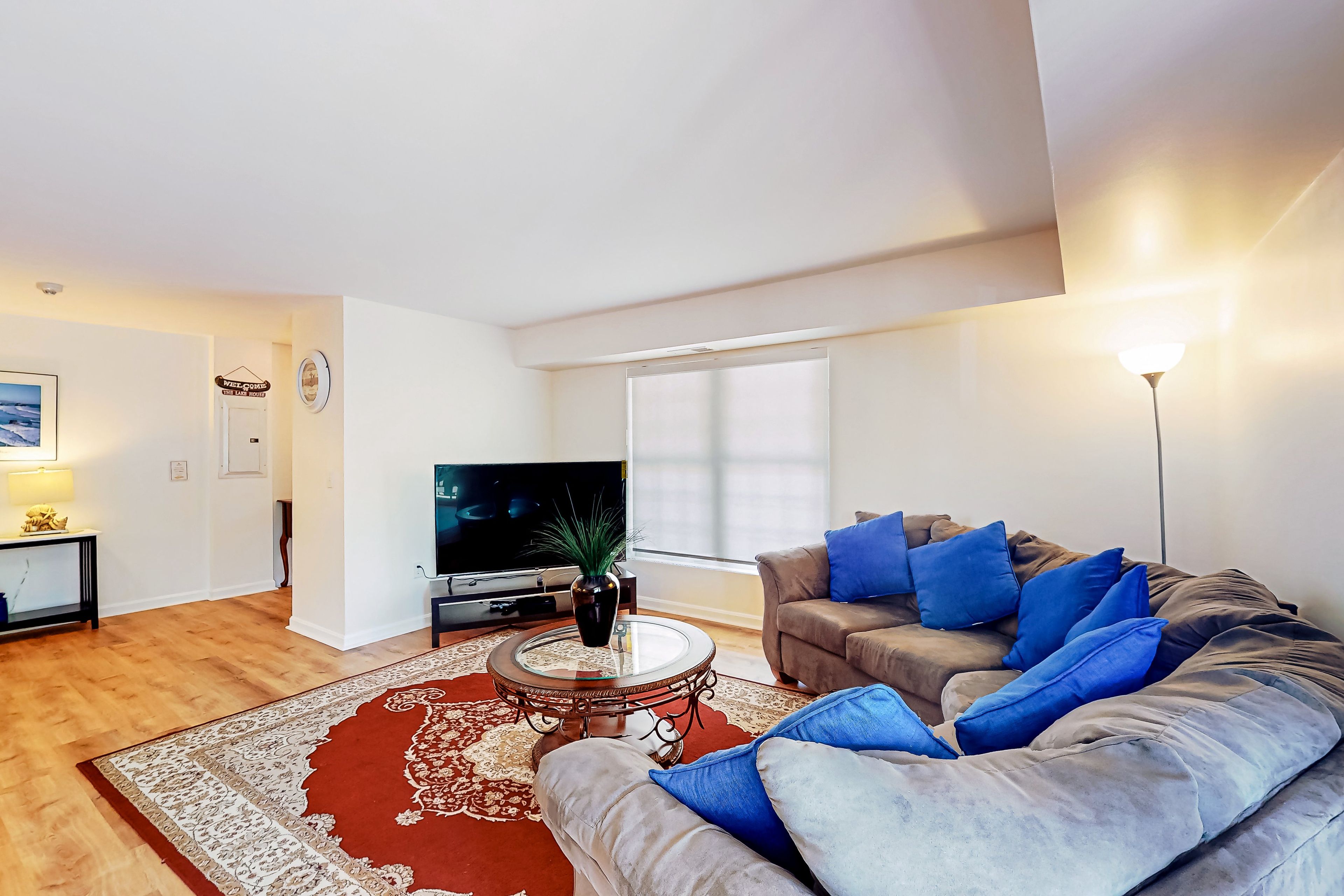 Gather on the living room's sectional with the TV and blue cushions for a relaxed evening after your Lake Anna outing.
