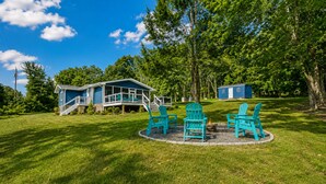 A house with a porch, a deck, and a fire pit area with chairs. - Lakefront, dog-friendly home with dock, paddleboards & firepit (Mineral)
