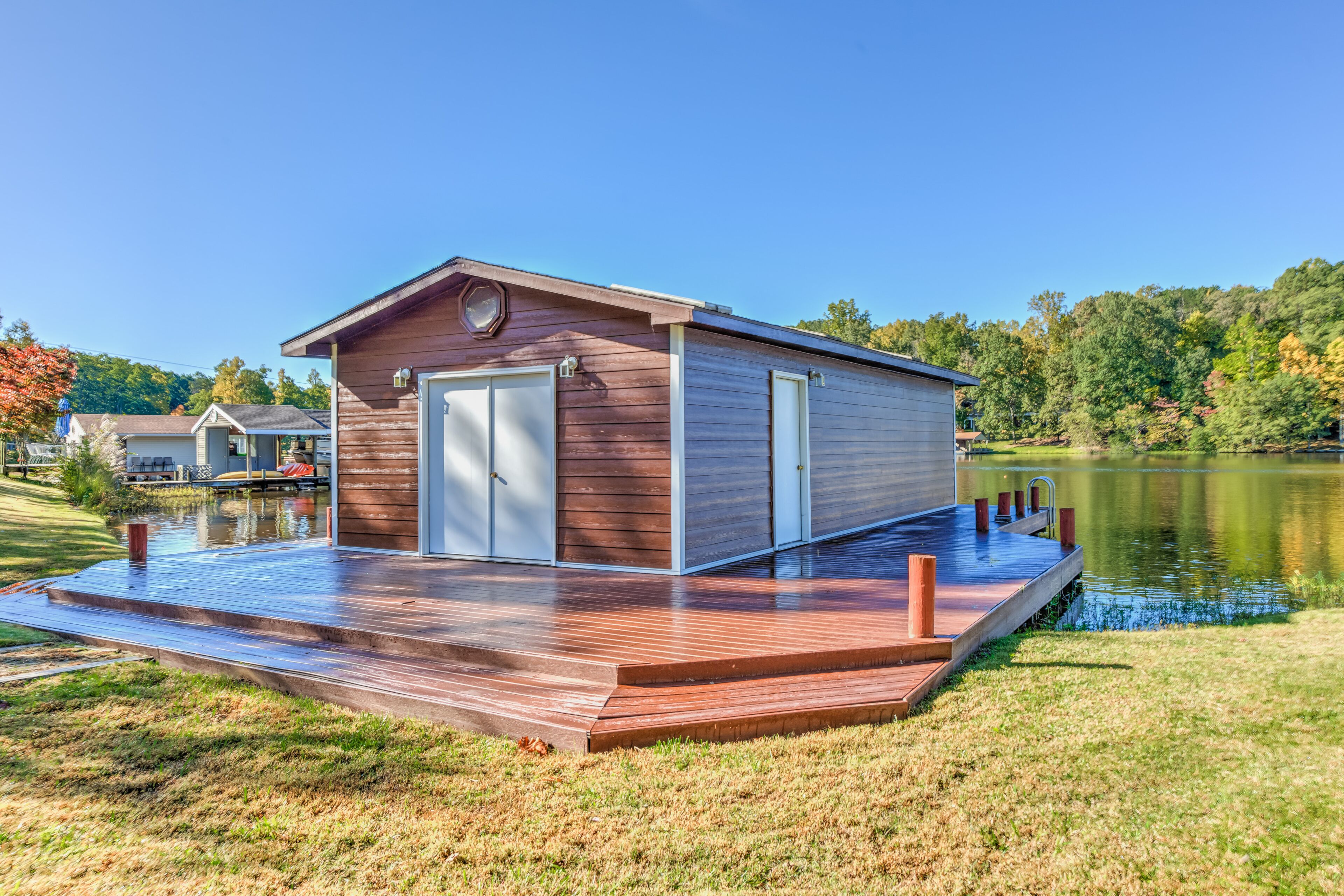 A wooden cabin with a deck, a door, and a window.