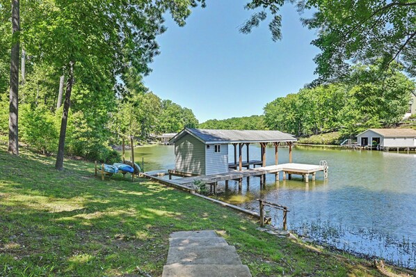A lakeside cabin with a dock, surrounded by trees and a clear sky. - Spacious lakefront home w/ boat dock, fire pit & pool table - dogs OK (Mineral)