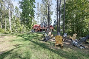 A cabin with a deck, surrounded by trees, and outdoor seating. - Lakefront Dog Friendly with boat mooring, deck, hot tub, game room & fast WiFi (Bumpass)