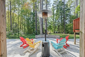 An outdoor seating area with Adirondack chairs and a wood-burning stove. - Lakefront Dog Friendly with boat mooring, deck, hot tub, game room & fast WiFi (Bumpass)