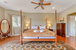 A spacious bedroom with a four-poster bed, a large mirror, and a wooden dresser. - Huge lakefront home with A/C, sunroom, boat ramp, WIFI,game room, deck, & kayaks (Louisa)