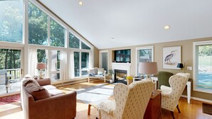 A spacious living room with large windows, a fireplace, and a comfortable seating area. - Pet Friendly, pool table, ping pong, fire pit, free WIFI (Bumpass)