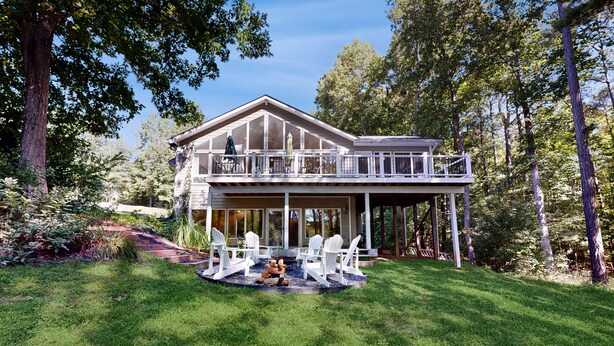 A two-story house with a balcony, surrounded by a well-maintained lawn and trees. - Pet Friendly, pool table, ping pong, fire pit, free WIFI (Bumpass)