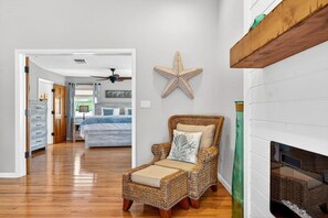 A room with a wicker chair, a starfish decoration, and a fireplace. - Blue Lagoon 3BR Pool Home Near the Beach (Redington Beach)