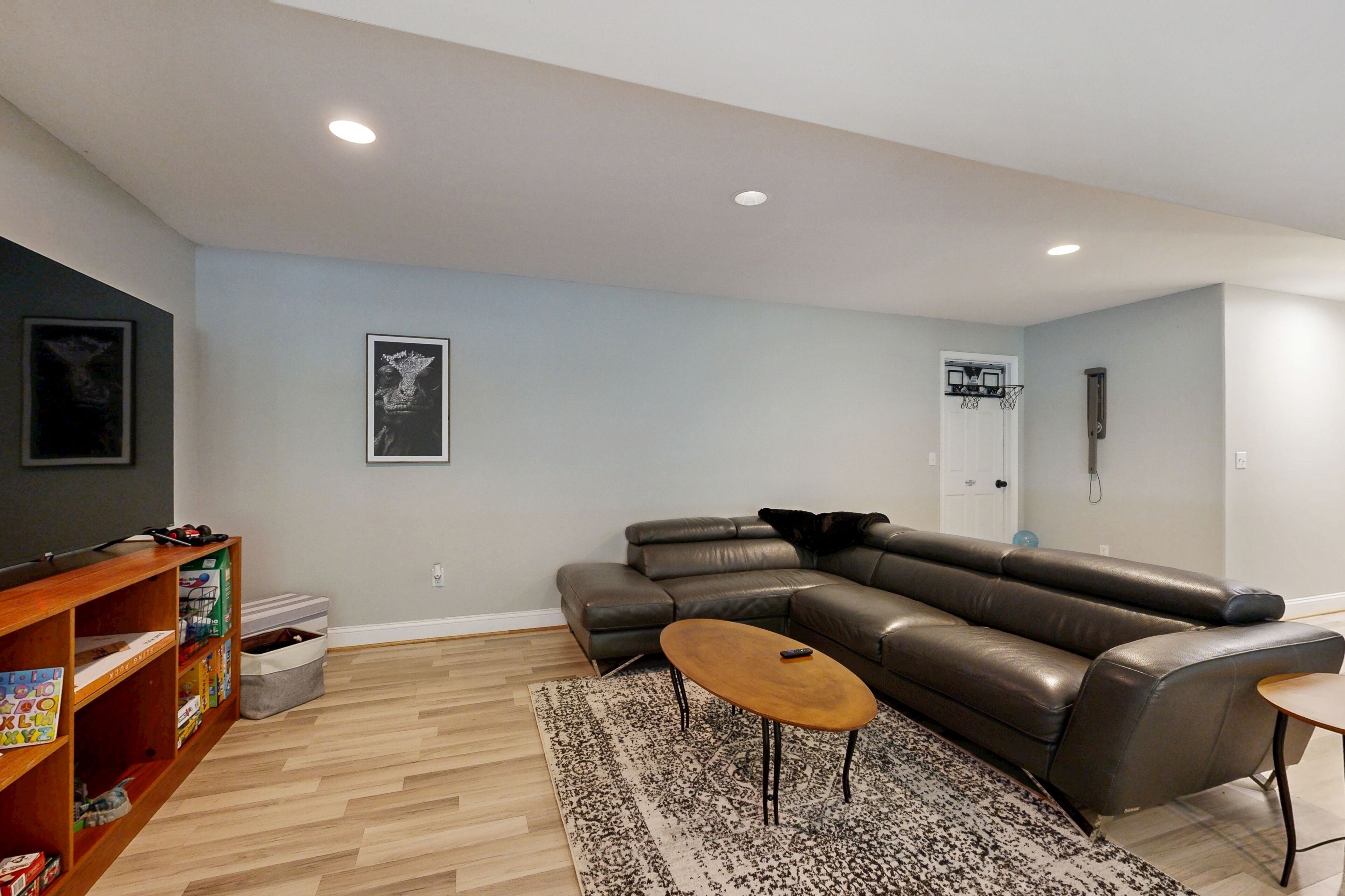 A modern living room with a sectional sofa, a coffee table, and a bookshelf.
