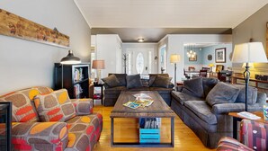 A cozy living room with a sofa, a coffee table, and a bookshelf. - Tranquil lakefront retreat with hot tub, screened porch, kayaks, and more (Bumpass)