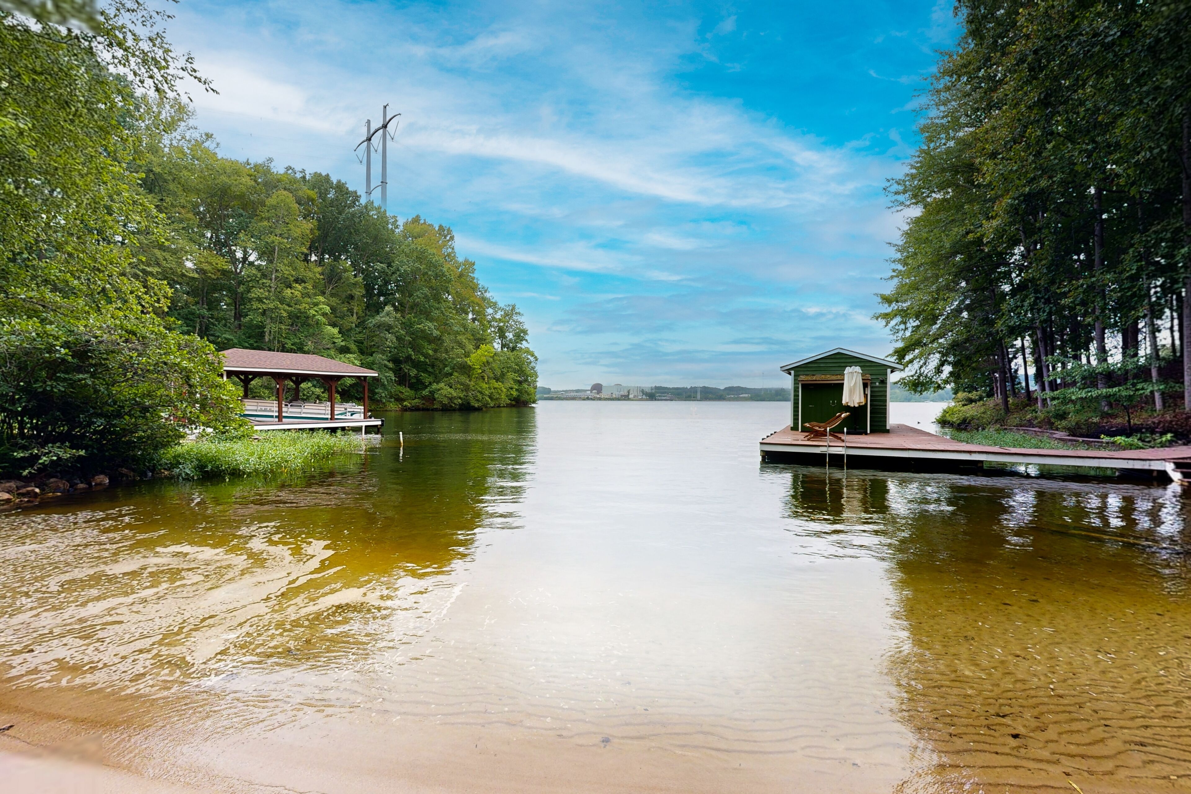 A tranquil lakeside setting with a small dock and a gazebo.