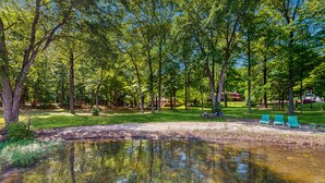 A serene park with a pond, green lawn, and a building in the background. - Rustic lakehouse with views, kayaks, Wifi, Central AC & cozy firepit nights (Bumpass)
