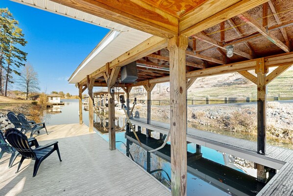 Una terraza techada con sillas y vistas a un lago.