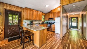 Une cuisine avec des meubles en bois, un plan de travail en granit et un îlot central.