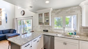 A kitchen with white cabinets, a granite countertop, and a dishwasher. There is a window with a view of the outside. - Three-story lakefront home w/ covered boat slip, and tennis/pickleball access (Mineral)