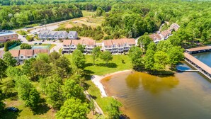 An aerial view of a residential area with multiple houses, a dock, and a body of water. - Three-story lakefront home w/ covered boat slip, and tennis/pickleball access (Mineral)