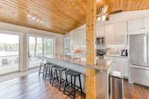 Una cocina moderna con techo de madera, ventanas amplias y vistas al exterior.