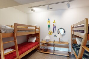 Une chambre avec un lit superposé, un bureau, une lampe et des décorations murales.