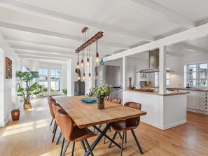 A spacious kitchen with a central island, wooden flooring, and pendant lighting. - 4 Star Holiday Home in Blokhus (Blokhus)