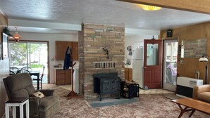 Una sala de estar con chimenea, un comedor y una cocina.