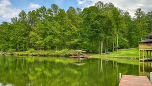 A tranquil lake with a wooden dock and a gazebo. - Sprawling waterfront home with kayaks, game room, and hot tub (Mineral)