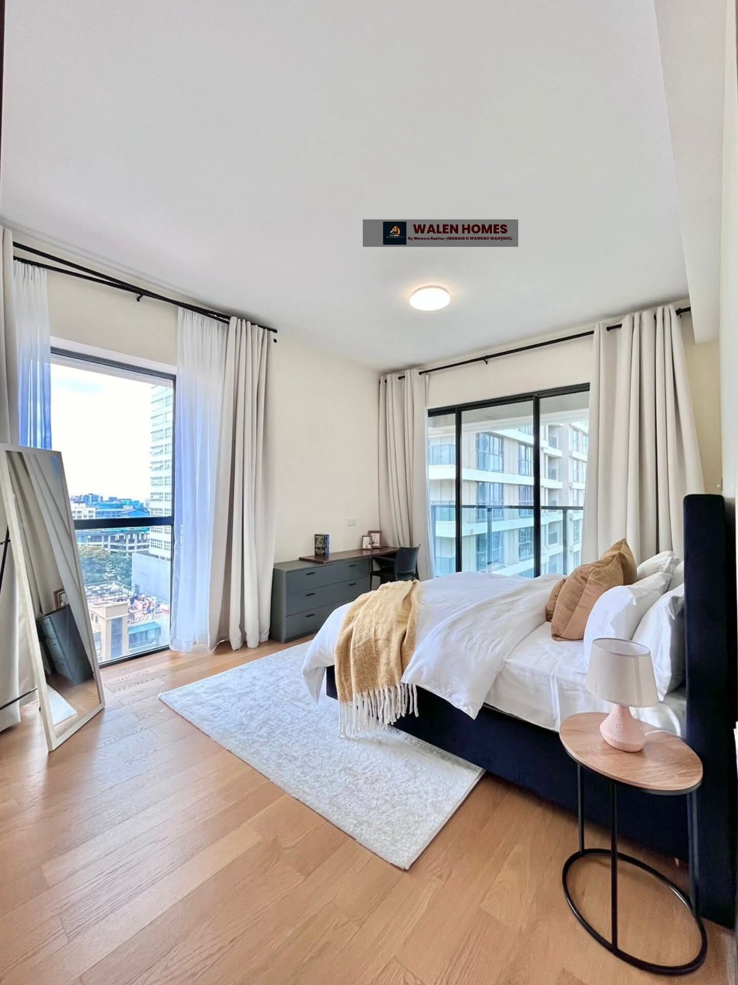 Quarto de hotel moderno com uma cama grande, uma escrivaninha e vista para a cidade.