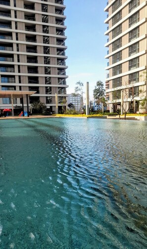Een zwembad met helder water, omringd door moderne wolkenkrabbers.