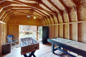 Un espace de loisirs intérieur équipé d’un baby-foot et d’une table de billard.