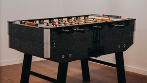 A foosball table in a room with a hanging light fixture. - Villa La Fortezza With sea View (Marina)