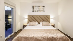 A bedroom with a bed, a headboard, bedside tables, a window, and a wall-mounted artwork. - Villa La Fortezza With sea View (Marina)