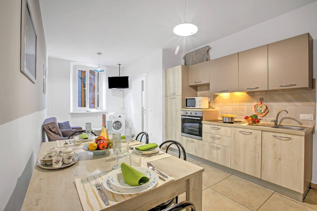 A modern kitchen with wooden cabinets, a built-in oven, and a microwave.