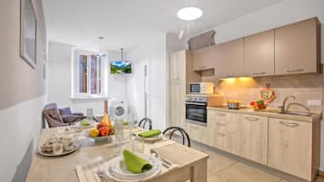 Una cucina moderna con mobili in legno, forno integrato e microonde.