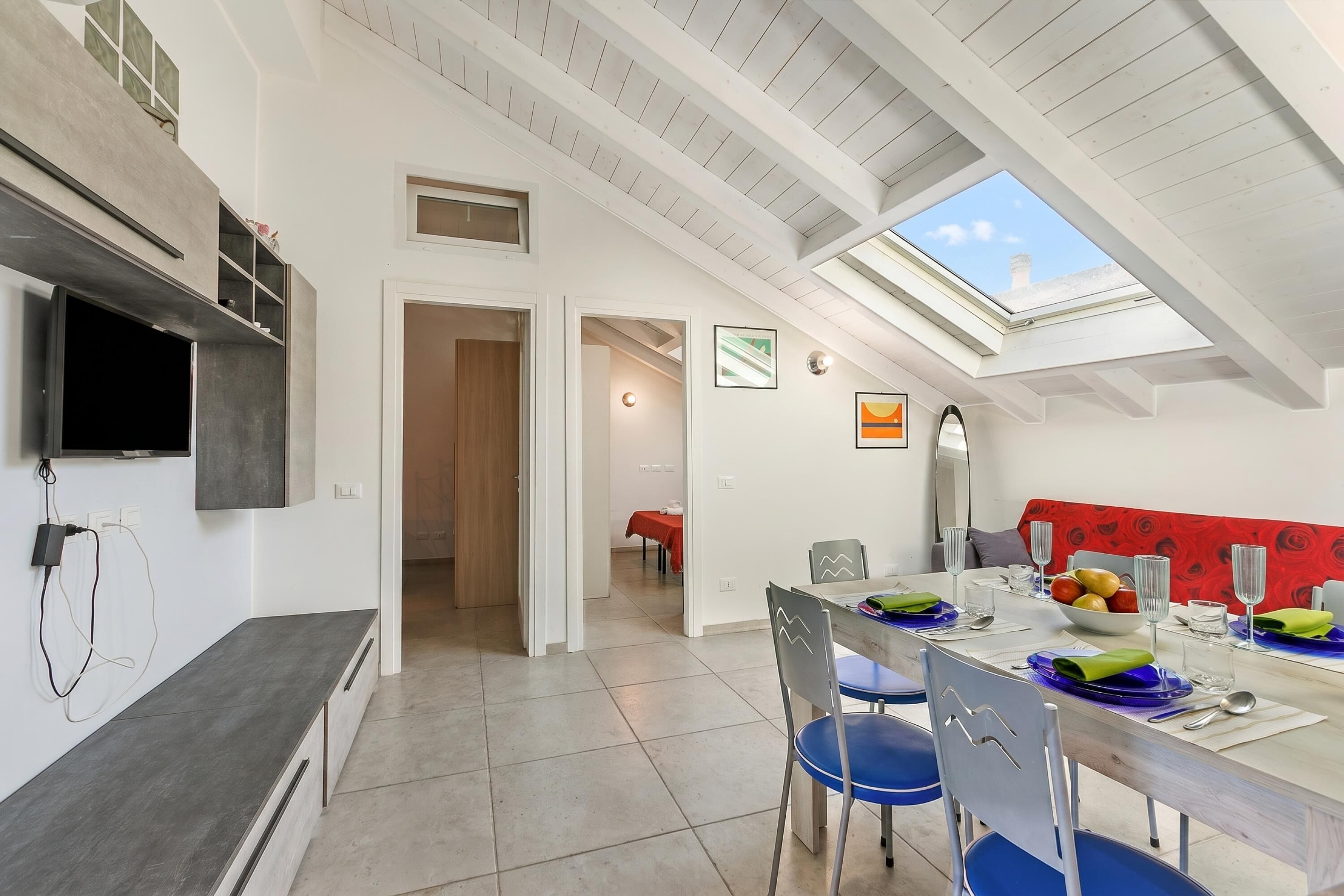 Ein moderner Essbereich mit hoher Decke, Dachfenster und Blick zum Himmel.