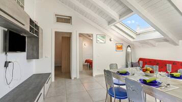 Ein moderner Essbereich mit hoher Decke, Dachfenster und Blick zum Himmel.