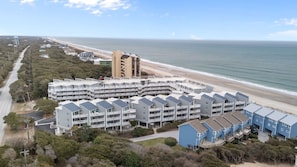 Ein Küstenhotel mit mehrstöckigen Gebäuden, Blick auf den Strand und einem Parkplatz.