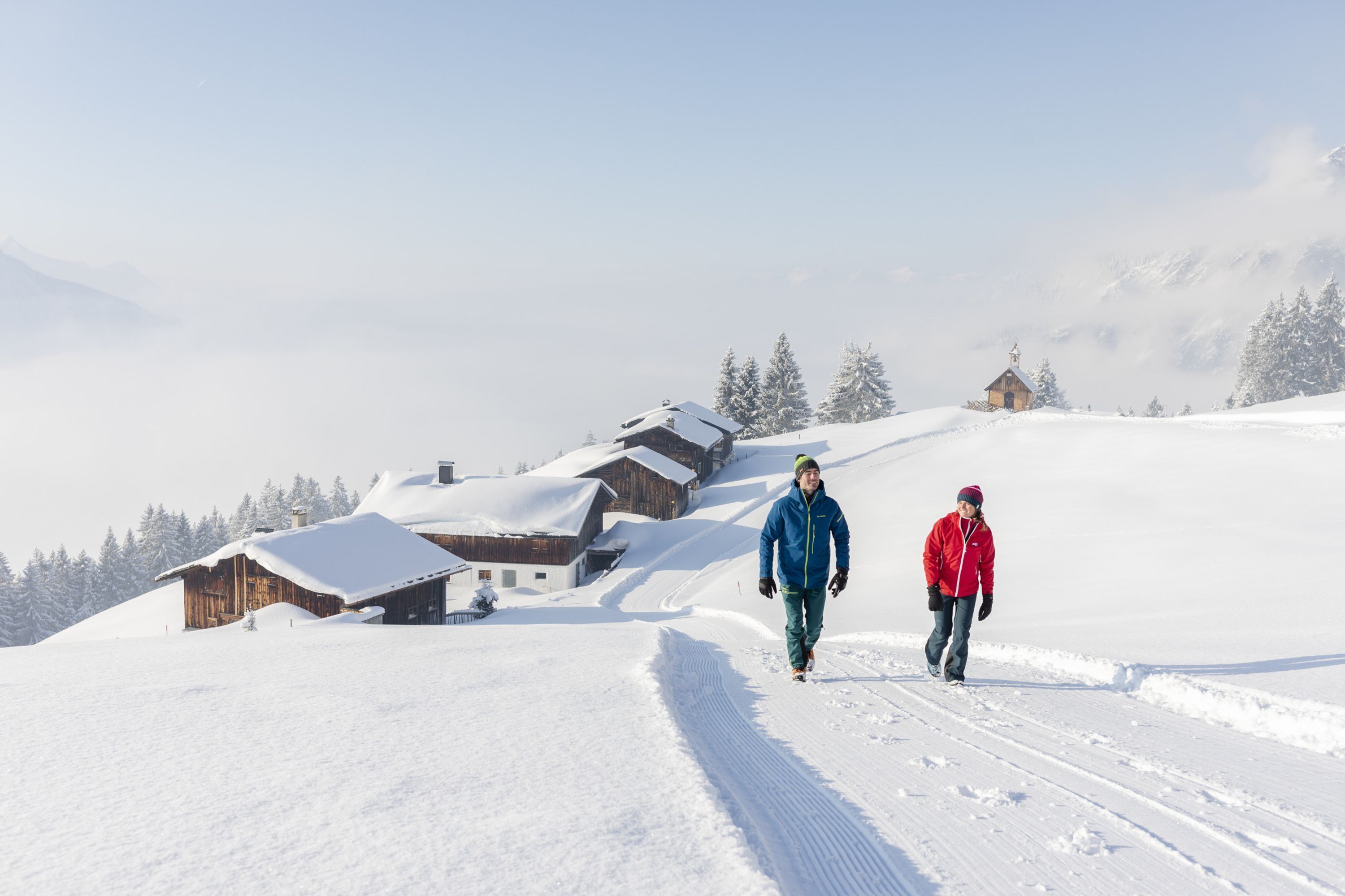 Eine verschneite Landschaft mit Holzhütten und einem klaren Himmel.