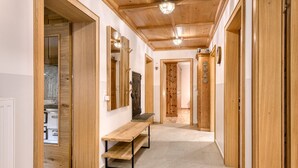 A hallway with wooden doors, a bench, and a mirror. - Ferienhaus Galgenul in St Gallenkirch (Sankt Gallenkirch)