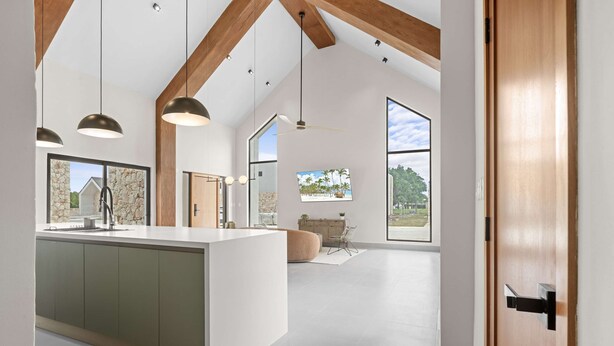 A spacious kitchen with a central island, pendant lighting, and large windows offering views of the outdoors. - NOK Luxury 2BR Equestrian Retreat With Private Pool in Punta Cana (Punta Cana)