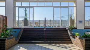 A set of stairs leading to a balcony with a view of the sea, a sign prohibiting smoking, and potted plants. - Durban Spa (Durban)