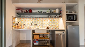 A compact kitchen with a microwave, refrigerator, and a small sink area. - La Tanca Del Conte - Suite Banano: Private Pool, Sea View, Nature Retreat (Muravera)