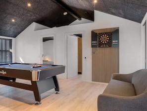 A modern room with a pool table, a dartboard, and a comfortable seating area. - 4 Star Holiday Home in Lokken (Lokken)