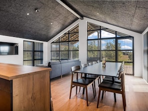 A modern interior with a dining area, a sofa, and large windows. - 4 Star Holiday Home in Lokken (Lokken)