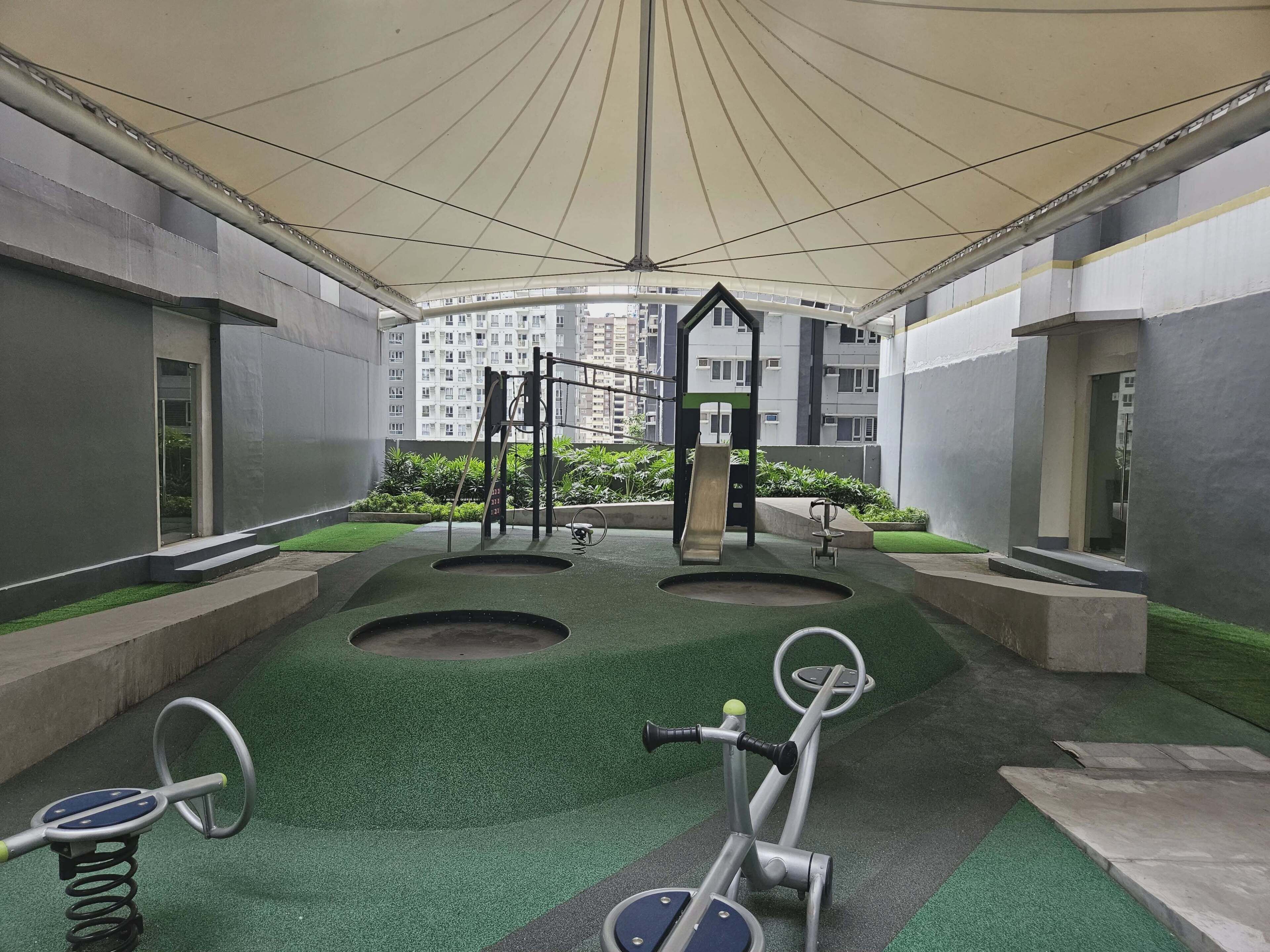 An indoor playground with exercise equipment, a slide, and a climbing structure.