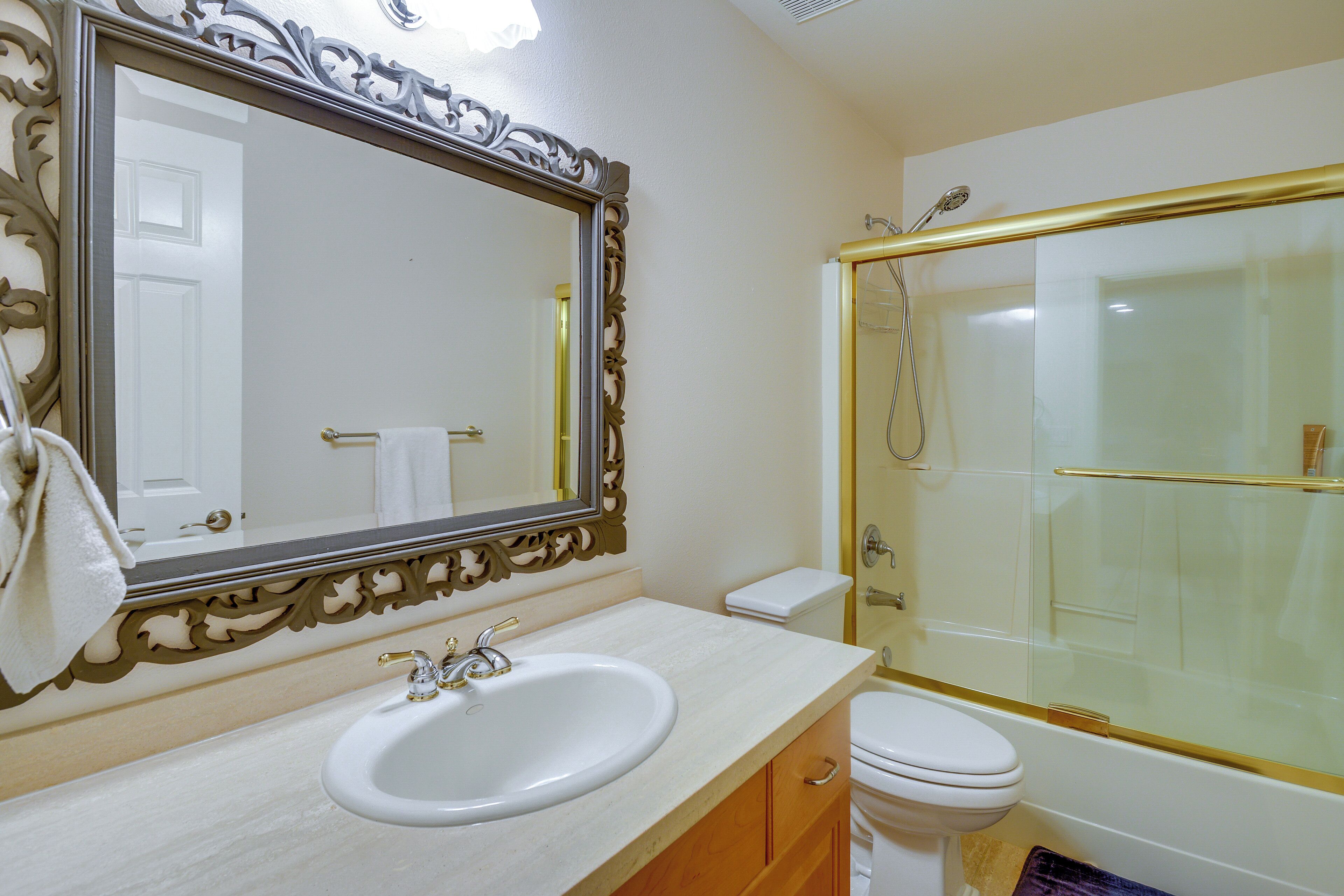 A bathroom with a sink, toilet, and shower.